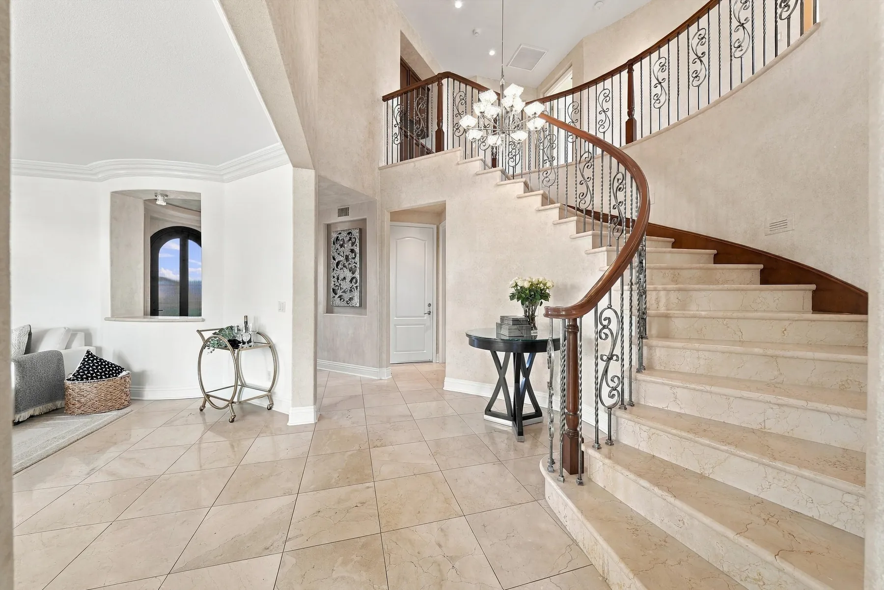 Entry with curved single-slab staircase and chandelier