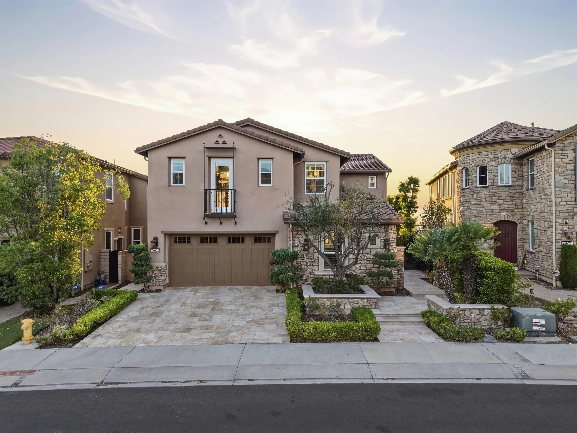 27631 Manor Hill at dusk, a two-story home with a stone driveway and landscaped entry